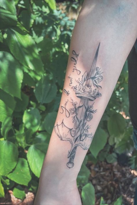 A sword tattoo wrapped in foliage with a queens crown sitting on it and a wyvern flying across it, with a quote "You do not yield" from Sarah J Maas series, Throne of Glass. Maas Tattoo, Sarah J Maas Tattoo, Sarah J Maas Tattoo Ideas, Glass Tattoo Ideas, Throne Of Glass Tattoo, Book Inspired Tattoos, Book Lover Tattoo, Glass Tattoo, Bookish Tattoos