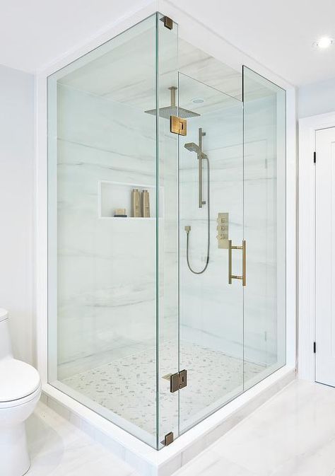 Perfectly designed seamless glass shower is fitted with marble herringbone floor tiles complementing marble walls that frame a niche and hold a modern brass shower kit paired with square rain shower head mounted to a marble clad ceiling. Floor To Ceiling Shower Door, Homemade Tiles, Clad Ceiling, Herringbone Shower Floor, Bathroom Shower Remodel, Marble Herringbone Floor, Herringbone Shower, Marble Walls, Tub To Shower Remodel