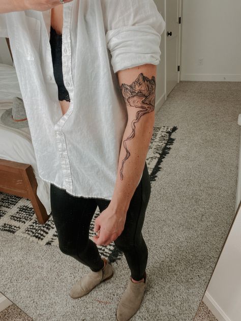 Woman’s minimal geometric mountain and lake tattoo in black ink. Back Tattoo Women Mountain, Water Tattoo Sleeve Women, River Inspired Tattoos, Waterfall Tattoo Minimalist, Cascading Tattoos, River Arm Tattoo, Upper Calf Tattoo Women, River Topography Tattoo, River Map Tattoo