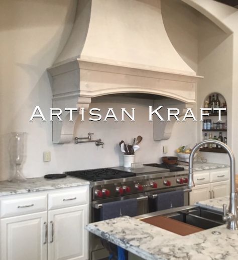 Rustic kitchen range hood made from cast stone in a kitchen with over a stove range. Marble counter top with a marble counter top island. Stainless steal faucet and a stainless steal pot filler faucet over the range. Cast Stone Range Hood, Oven Hoods, Limestone Kitchen, Stone Range Hood, Kitchen Hood Vent, Kitchen Mantle, Kitchen Range Hoods, Lakehouse Kitchen, Stove Hood