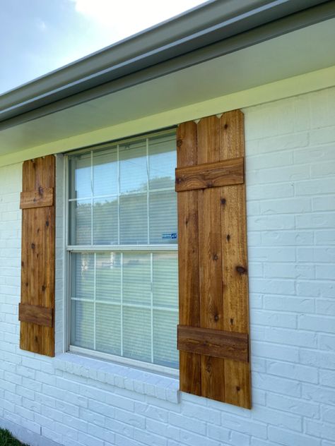 DIY shutters, made with cedar fence pickets, and hellmans clear sealer. Cedar Wood Shutters, Cedar Board And Batten Shutters, Wooden Outdoor Window Shutters, Farmhouse Wooden Shutters, White Brick House Cedar Shutters, Cedar Shutters On Brick House, Wooden Shutters White House, Wooden House Shutters, Barnwood Shutters Exterior