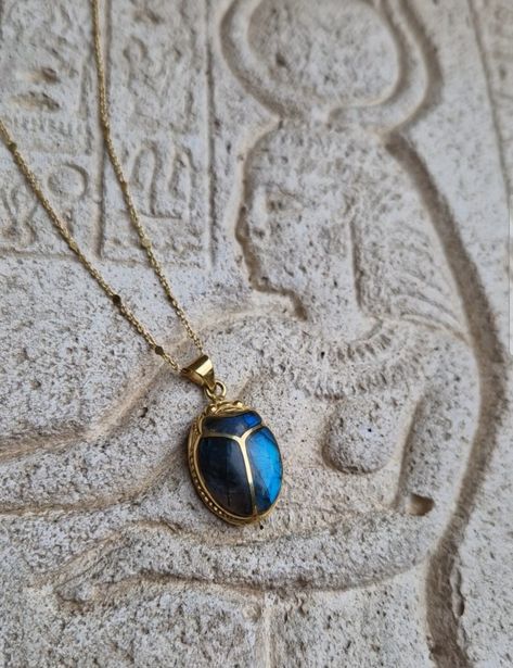 This amazing pendant will make you feel like a living goddess Hand-carved scarab, an ancient reproduction, inlaid with a genuine deep blue shimmering labradorite stone. The gem fits perfectly in the gaps of the beetle. A beautiful tribute to ancient Egypt and to the divine archetypes that we incarnate. In ancient Egypt, the fascinating Scarab Beetle was associated with the solar cycle, as a concept of rebirth and regeneration. The God Khepri was rising the sun every day before rolling it above the horizon, then carried it through the other world after sunset, just to renew it, again, the next morning. The decisive symbolism came from the association of the dung ball to the sun: the scarab rolling his dung ball provided an explanation of the sun's movement in the sky. Powerful amulet used a Beetle Jewelry, Scarab Jewelry, Egyptian Scarab, The Beetle, Scarab Beetle, Other World, Egyptian Jewelry, Egyptian Revival, Unusual Jewelry