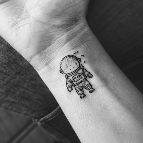 Embrace the universe on your skin with this minimalist astronaut tattoo, a symbol of adventure and the vastness of human curiosity. Save this cosmic inspiration and follow for more celestial wonders. This delicate ink captures the explorer within us all, nudging us towards the stars. Perfect for those who dream of interstellar journeys and the mysteries beyond our world. 🚀✨ #SpaceTattoo #MinimalistInk #AstronautArt #CelestialBeauty #InkInspiration #AI Astronaut Sitting On Moon Tattoo, Spaceman Tattoo Simple, Astronaut Tattoo Minimalist, Interstellar Tattoo Minimalist, Walter Mitty Tattoo, Simple Astronaut Tattoo, Astronaut Tattoo Design, Milky Way Tattoo, Spaceman Tattoo