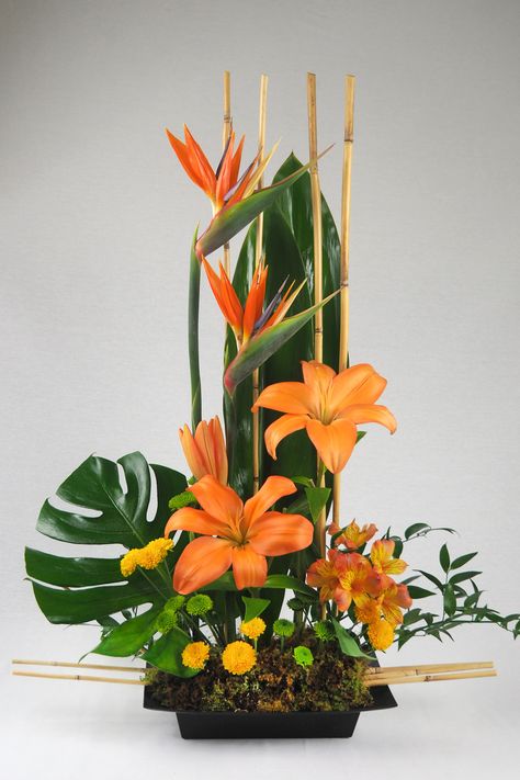 Spiky, brilliantly colorful birds of paradise are a dramatic and long-lasting addition to any flower arrangement. With their beak-like appearance, these unique "blooms" look like winged creatures poised for flight! Matched with fresh flowers and exotic leaves. - Hand delivered in a square black container. Hawaiian Flower Arrangements, Rustic Flower Arrangements, Arreglos Ikebana, Floral Art Arrangements, Tropical Floral Arrangements, Tropical Flower Arrangements, Winged Creatures, Sunflower Arrangements, Birds Of Paradise Flower