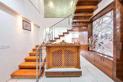 A beautiful concept of design and use of space. Carved temple by the staircase.   Urbanclap Interior Designer: @studioignitus   #homes #interiors #interiordesign #homeinteriors #interiordesigner #wooden #staircase #carvedtemple #woodentemple #beautiful #interiorsforall #urbanclap #uchomes #ucprofessionals Wooden Pooja Mandir Designs, Wooden Temple Design, Wall Mandir, Under Stairs Design, Pooja Mandir Designs, Pooja Room Designs, Room Under Stairs, Mandir Designs, Small Room Interior