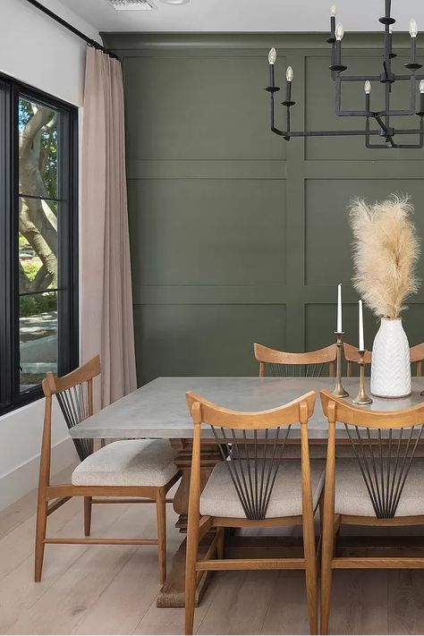 This sophisticated dining room elevates entertaining with a stunning green wood accent wall.  The rich wood tones of the table and chairs complement the natural element, creating a warm and inviting atmosphere. Perfect for hosting memorable meals with a touch of modern flair. #diningroom #diningroomset #elegantdining #furniture #interiordesign #homedecor #classicdesign #timelessstyle #entertaining #dinnerparty #familymeals #greenaccentwall #greendecor #woodaccents #naturalliving #biophilicdesign Dark Green Dining Room Accent Wall, Hunter Green Dining Room Walls, Two Tone Wall Dining Room, Green Wood Accent Wall, Green Wall Dining Room, Green Accent Wall Dining Room, Green Dining Room Paint, Dark Green Dining Room, Dining Room Color Palette