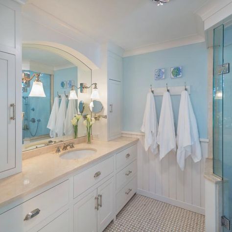 Blue and White Cottage Bathroom With Cane Mirror | HGTV Black Herringbone Tile, Coastal Bungalow, Sherwin Williams Sea Salt, Installing Wainscoting, Herringbone Tile Floors, Frameless Glass Doors, Gray Vanity, Cottage Bathroom, Blue Cottage