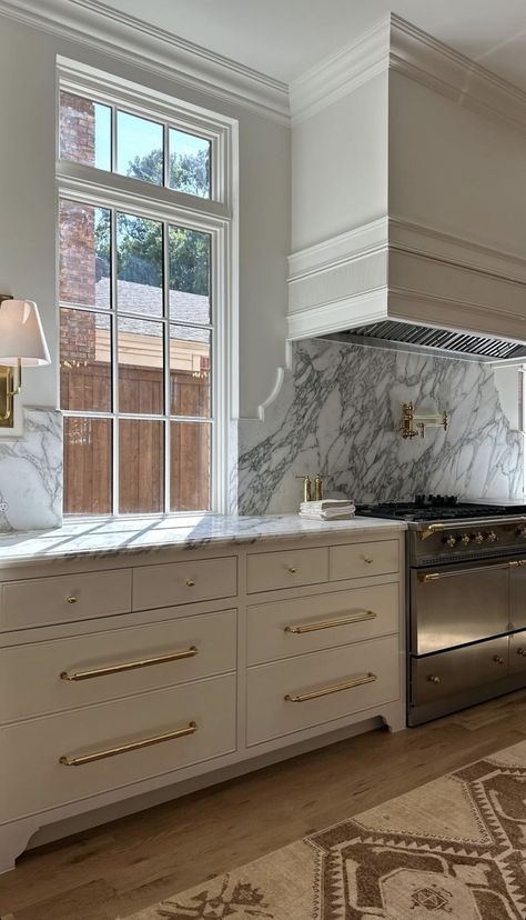 Plaster Hood Between Windows, Waterfall Marble Island, Range Between Two Windows, Brass Vent Hood, Oversized Kitchen Island, Full Overlay Cabinets, Range Kitchen, Double Island, Double Island Kitchen