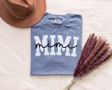 Get ready to love this Mimi Shirt! Is the perfect gift for the grandma who loves simple vibes! *QUICK FACTS* * 100% ring spun Cotton * Machine Washable     *CARE INSTRUCTIONS* Machine wash cold; do not bleach; Tumble dry: medium; Iron, steam, or dry: low heat; Do not dry clean Turn inside out Do not iron directly on the print * S I Z I N G * Sizing is unisex  * HOW TO ORDER * If you're not sure what size is best for you. Follow the size chart on the listing and compare measurements to an item yo Mimi Shirt Ideas, Simple Vibes, Mimi Gifts, Gift From Grandkids, Mimi Gift, Announcement Pregnancy, Pregnancy Reveal, Gifts Baby, Notes Design