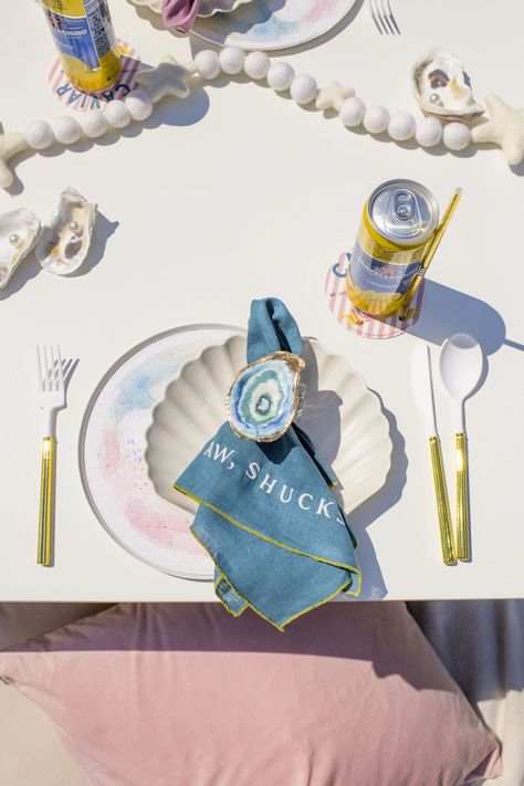 an oyster-themed birthday party featuring custom napkins with oyster puns, shell and pearl plates, and a pearl garland The World Is Your Oyster Party Theme, Oyster Themed Party, Pearl Party Theme, Coastal Dinner Party, Pearl Plates, Oyster Party, Childhood Birthday, Whimsical Backyard, Coastal Italian