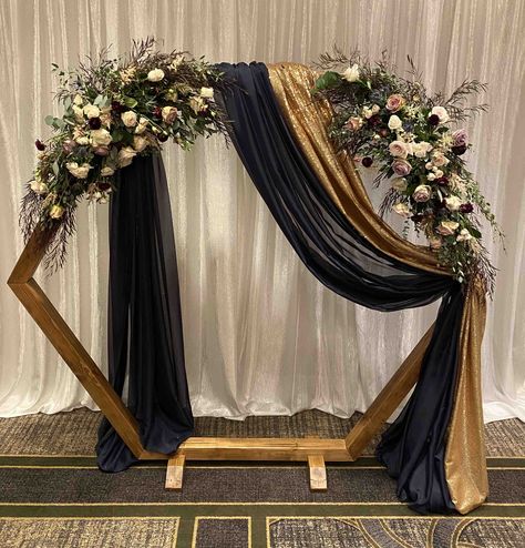 Hexagon wooden arch with navy voile and gold glimmer draping @ The Sheraton Suites Akron / Cuyahoga Falls (provided by Sitting Pretty Linens, Akron Ohio). Diy Engagement Decorations, 50th Anniversary Party Decorations, Wedding Ceremony Decorations Indoor, Haldi Ceremony Decorations, Arch Inspiration, Arch Designs, Gold Drapes, Entrance Garden, Draping Wedding