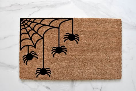 SPIDER WEB DOORMAT Welcome to our web. Our spider welcome mat is the perfect way to create a cute and spooky Halloween entryway. Front door mats make perfect wedding, housewarming, and birthday gifts!MATERIAL: natural coir front with a durable vinyl backingSIZES: 18" x 30" and 1/2 inch thick CARE: shake or vacuum to clean and refreshDESIGN: hand-painted with durable outdoor all-weather paint This hand-painted doormat is the perfect decorative accent to any entryway! Made with 100% coir, which ar Spider Web Door Mat, Halloween Door Mat Ideas Diy, Spooky Rugs Diy, Sip And Paint Halloween Door Mat, Front Door Mat Ideas For Fall, Door Mat Painting Diy Halloween, Doormat Ideas Halloween, Halloween Door Mat Painting, Halloween Diy Door Mat