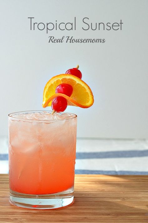 Tropical Sunset Cocktail | Real Housemoms | #cocktail #tropical Apple Juice Cocktail, Fruit Juice Cocktails, Juice Splash, Sunset Cocktail, Drink Garnishing, Cocktail Garnish, Tropical Sunset, Flavored Vodka, Tropical Drink