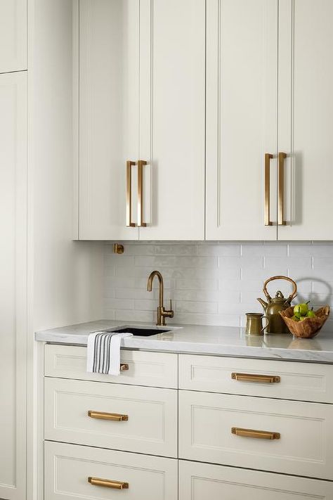 If you’re thinking about giving your off white kitchen a little upgrade, adding some gold or brass accents could be perfect. They add a warm, elegant glow that really makes the space pop. It’s a fun way to make your kitchen feel extra inviting and stylish, perfect for cooking up a storm or having friends over. #kitchencabinets #offwhitecabinets #kitcheninspo Off White Kitchen Cabinet Colors, White Kitchen Cabinet Colors, Gold Tiles Kitchen, White And Brass Kitchen, Neutral Kitchen Cabinets, White Kitchen Wall Tiles, Off White Kitchen, Gold Kitchen Hardware, Off White Kitchen Cabinets