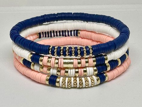 Set of 4 Navy, Light Coral, and White, hand beaded, stretch bracelets. Bracelets are made with 6mm Heishi beads with gold accents. Can customize with wording of your choice using white beads with gold letters. Cute Heishi Bracelets Ideas, Heshi Bead Ideas, Bracelets Stacking, Bracelet Heishi, Heishi Jewelry, Navy Bracelet, Womens Gifts, Stacked Bracelets, Diy Jewelry Rings