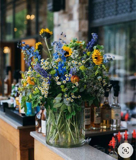 Sunflower Table Decoration, Sunflower With Blue Flowers, Yellow Blue Floral Arrangement, Delphinium Arrangement Vase, Blue Floral Table Arrangements, Wildflower Vase Arrangements, Blue And Yellow Flower Centerpieces, Sunflower And Wildflower Bouquet, Diy Wildflower Wedding Decor