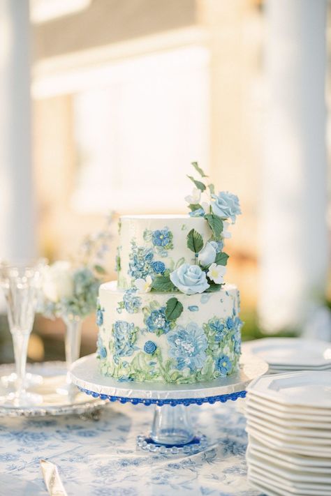 Two tier blue florals painted Buttercream wedding cake in a blue floral vintage linen with toasting glasses. Click the photo to meet the baker. #paintedbuttercreamweddingcake #weddingcakeidea #weddingcaedesign Blue And Green Wedding Cake, Blue Green Cake, Wedding Cake Designs Blue, Blue Floral Cake, Blue And White Cake, Wedding Cake Hydrangea, Hydrangea Cake, Bohemian Wedding Cake, Quince Decor