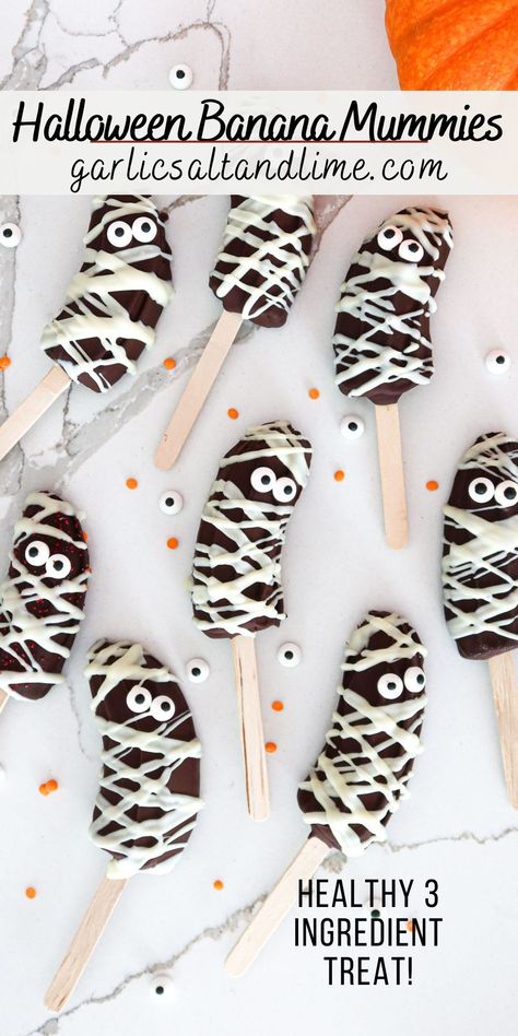 Banana mummies arranged on a white countertop. Ghost Banana Pops, Halloween Fruit Treats For School, Halloween Bakes Kids, Halloween Festive Food, Daycare Halloween Party Food, Kid Halloween Party Food Ideas, Banana Halloween Treats, Halloween Party Fruit Ideas, Halloween Party School Treats