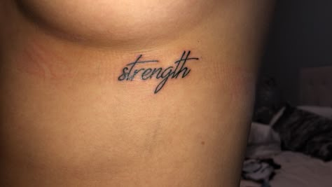 Black cursive strength underboob tattoo Strength Neck Tattoo, Underboob Word Tattoo, Underboob Tattoo Words, Small Tattoos Underboob, Underboob Name Tattoo, Underboob Tattoo Black Women, Feminine Strength Tattoo, Underboob Tattoos Words, Underboob Tattoo Writing