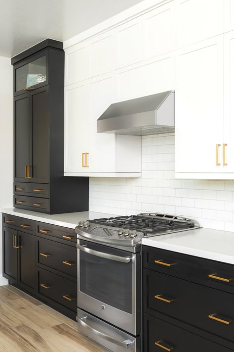 Kitchen with black drawer bases and white uppers. Accented with gold hardware and white subway tile. #cabinetsolutionsusa #weenrichhomelife #kitchen #cabinets #interiors #interiordesign Black And White Kitchen Gold Hardware, Black Bottom Cabinets White Upper Kitchen, Black Base Cabinets With White Uppers, Kitchen Black Cabinets Gold Hardware, Black Cabinets White Subway Tile, White Upper Black Lower Cabinets, Kitchen Black Bottom Cabinets, Black And White High Gloss Kitchen Cabinets, Half Black Half White Kitchen Cabinets