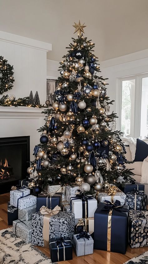 Modern black and white Christmas tree with silver, navy, and gold ornaments, surrounded by gifts and a white fireplace Navy Gold White Christmas Tree, Gold And Navy Christmas Tree, Manly Christmas Tree, Christmas Tree Ideas Blue And Gold, Navy Blue And Silver Christmas Tree, Navy Blue Christmas Tree Color Schemes, Black And Blue Christmas Tree, Navy Blue And Gold Christmas Tree, White Glam Christmas Tree