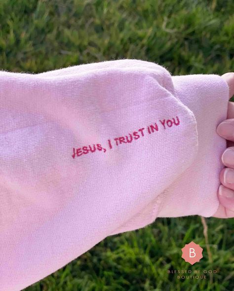 This Jesus I Trust In You pink sweatshirt will keep you warm in the colder months. A pre-shrunk, classic fit sweater that's made with air-jet spun yarn for a soft feel. The inside of the left wrist has embroidery which reads, "Jesus I Trust In You". Look at this message as a constant reminder of the love and mercy our Lord pours upon us each day. .: 50% cotton, 50% polyester .: Pre-shrunk .: Unisex, Classic fit .: Rib knit collar with spandex .: Double-needle stitched collar, shoulders, armholes Pink Christian Sweatshirt, I Love Jesus Shirt, Christian Clothing Design, Jesus I Trust In You, Embroidery Sweatshirt Designs, Christian Boutique Ideas, Christian Sweatshirts For Women, Cute Christian Sweatshirts, Jesus Sweaters