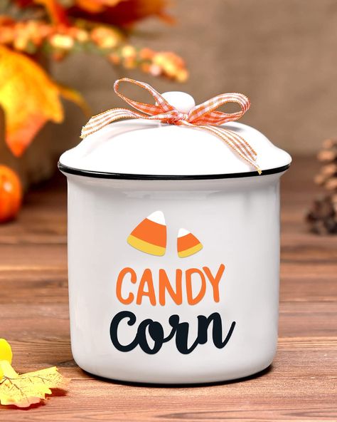 PRICES MAY VARY. Candy Corn Ceramic Canister-The package includes a jar printed with "Candy Corn". This canister is made of high-quality ceramic. Comes with a lid tied with a buffalo check bow. Mini Halloween Candy Holder-The canister measure approximately 4.9" tall and 3.7" wide.Ideal for holding some sweet candy, kitchen sauces, small Halloween ornaments, Halloween little tricks, etc. Autumn Holidays Table Centerpiece-Now is the time to start looking for fall holiday decorations for this year. Trick Or Treat Bowl, Candy Kitchen, Halloween Gift Baskets, Holiday Table Centerpieces, Fall Candy, Ceramic Canister, Cozy Candles, Candy Holder, Farmhouse Decoration