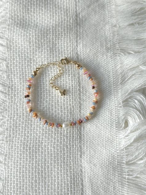 FOR OTHER DAINTY BEADED BRACELETS: https://www.etsy.com/ca/shop/ArtiChouXCanada?ref=seller-platform-mcnav§ion_id=46088511 Bracelet Length: 13-18cm (5.1-7 inches) with a 14k gold filled or sterling silver extender. This bracelet features a variety of stunning fall pastel colors: orange, brown, pink, cream, white, blue, and 18k gold filled seed beads. It also contains a freshwater pearl.  Thread may be visible since it is a handmade product   SIZING  Wrap a soft measuring tape snugly around the widest part of your wrist. Add 1.27cm (0.5in) to that measurement to determine the right bracelet size.  MATERIALS  - Japanese MGB glass seed beads(2x4mm) - 18K gold filled or sterling silver beads of 2mm - Freshwater pearl - 14K gold filled or sterling silver extender  CARE INSTRUCTIONS   To maintain Fall Pastel Colors, Pastel Fall, Fall Bead, Pearl Bracelet Gold, Autumn Bracelet, Seed Bead Bracelet, Freshwater Pearl Bracelet, Seed Bead Bracelets, Bead Jewelry