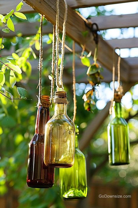 Whether you’re looking for a windchime substitute or just another way to decorate your outdoor space, think about hanging up glass bottles. Hanging Glass Bottles, Windchimes Outdoor, Reserve Home, Book Organizer, Bottle Garden, Glass Bottles Decoration, Garden Decor Ideas, House Plant Care, House Plant