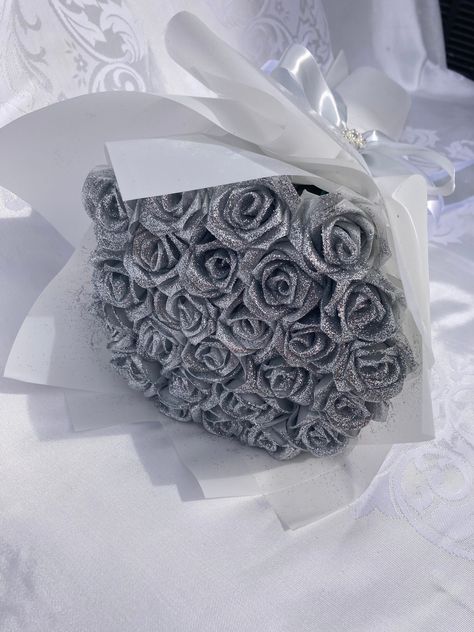 Introducing our DIAMOND bouquet! Beautiful handmade satin rose bouquet with sparkly, silver glitter. Great for anniversaries, birthdays, holidays, weddings, graduations or simply to show someone you're thinking of them. This bouquet has a lean and long luxurious look due to the slim stem.  Message us for custom requests. Dimensions are included in pictures, but depend on bouquet size/number of roses. The pictured bouquet has 25 roses. Please don't hesitate to message us with questions! Glitter Flower Bouquet, Silver Rose Bouquet, Large Rose Bouquet, Silver Flower Bouquet, Satin Rose Bouquet, Diamond Bouquet, Silver Bouquet, Ribbon Rose Bouquets, Luxury Bouquet