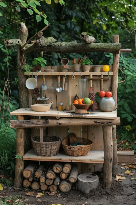 Rustic outdoor kitchen with wooden shelves, cooking utensils, and fresh vegetables in a garden setting. Mud Kitchen Garden Area, Diy Garden Playground, Mud Art For Kids, Nature Kitchen Design, Mud Kitchen Under Playset, Homestead Wood Projects, Dirt Kitchen Kids, Outdoor Kitchen Kids Diy, Forest School Mud Kitchen