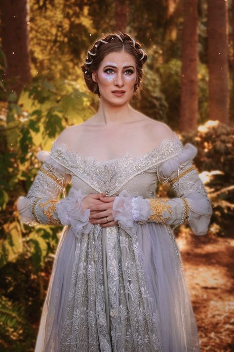 A white woman stands in the woods at golden hour. She has brown hair and is wearing an iridescent silvery embroidered off the shoulder Renaissance dress Just Breathe Dress, Ever After Dresses, Ever After Dress, Cinderella Collection, Cinderella Dress, Ren Fair, Cinderella Story, A Cinderella Story, Cinderella Dresses