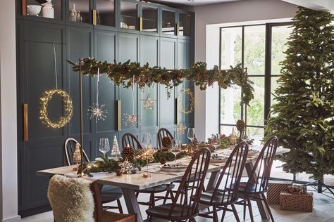 A magical Christmas table setup with a garland over the table. Over Table Christmas Decorations, Small Christmas Table Decor, Christmas Table Decorations Round Table, Wooden Table Runner, Christmas Dinner Table Decor, Table Decor Inspiration, Christmas Table Decor Ideas, Christmas Dining Room Decor, Table Decorations Christmas