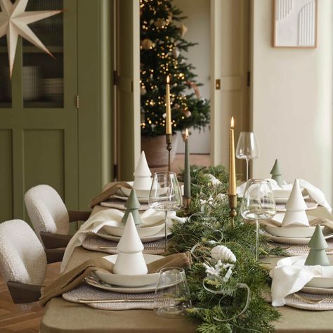 Opt for a simple, Scandinavian-inspired design. Use a neutral color palette of whites, greys, and natural woods. Include minimalist centerpieces with geometric shapes, simple candles, and soft fabric napkins. Pale Green Christmas Decor, Green Christmas Table Decor, Green Christmas Table, Ladies Christmas Party, Christmas Dining Table Decorations, Christmas Hosting, Christmas Dinner Table Settings, Minimalist Centerpiece, Dining Table Decorations