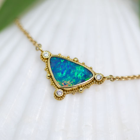 Capture the beauty of the tropical ocean and place it around your neck with this 18K Treasure Gold granulated pendant. This one-of-a-kind handcrafted necklace features a stunning 3.4ct blue/green Australian opal doublet and 3- 2mm VS/G-H round diamonds set in solid 18K gold made with 400 year-old sunken treasure recovered from the Caribbean. This is then suspended on an elegant 18K gold chain. Dimensions: 7/8” x 5/8” (24mm x 16mm) including bail. Necklace length overall: 18" Treasure Gold, Sunken Treasure, Sea Opal, Tropical Ocean, Products Photography, Round Diamond Setting, 18k Gold Chain, Handcrafted Necklace, Australian Opal