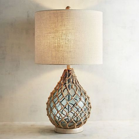 Rope and Sea Glass Table Lamp. Inspired by glass fishing floats, our teardrop sea glass table lamp with rope netting is sure to give your decor that nautical nod you’ve been looking for. Not only will this lamp inspire interesting fish tales, it will enlighten your family and friends with a convenient 3-way switch. #pier1 #beachhouse #coastal #nautical #affiliate Sea Glass Table, Coastal Lamps, Nautical Lamps, Nautical Table, Glass Fishing Floats, Room Lamp, Indoor Patio Furniture, Bedroom Lamps, Table Light