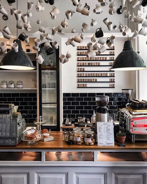 Coffee cups, in different designs & colors, suspended from the ceiling at different heights - as decor in this coffee shop. Menu on the wall offers flexibility with the use of letter board. #installation #letterboard #ceilingtreatment #walltreatment #interiordesign #coffeeshop #restaurantdesign Bar Deco, Café Design, Coffee Shop Interior Design, Cozy Coffee Shop, Design Café, Coffee Shops Interior, Bars And Restaurants, Best Bars, Coffee Shop Design