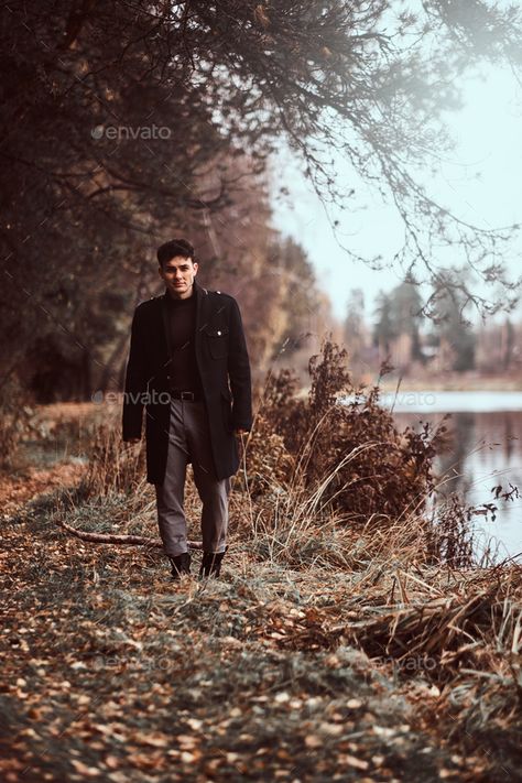 A handsome young man walking in the autumn forest. by fxquadro. A handsome young man wearing a black coat walking near a lake in the autumn forest. #Sponsored #walking, #autumn, #man, #handsome Forest Poses Men, Forest Photoshoot Men, Forest Poses, Therapist Photoshoot, Man In Forest, Reveal Photoshoot, Autumn Pics, Autumn Photoshoot, Poses Men