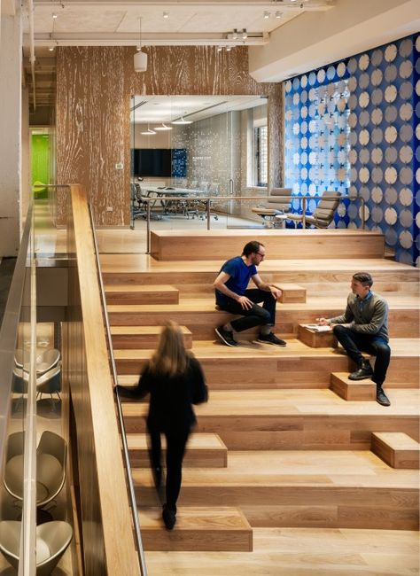 The heart of Pandora’s new office in Midtown Manhattan is a bright, double-height space first visible through a low, compressed entry. This central space provides a physical connection between the two floors via the grand stair on one side and takes advantage of the full height of both floors – about 25 feet – with a large screen made of translucent circular discs, elegantly coupled with figured aluminum hooks backed by a blue theatrical scrim. Google Office, New York Office, Stairs Architecture, Banda Aceh, Corporate Interiors, Creative Office, Office Designs, Office Seating, Workplace Design