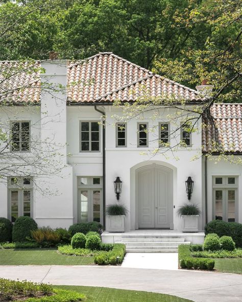 The front exterior of a white house with orange spanish tile shingles and a beautifully manicured green lush lawn Terracotta Roof House Exterior Colors Spanish, Houses With Tile Roofs, Meditteranean Style Home Exterior, Red Roof Stucco House, White House Red Tile Roof, Gray Mediterranean House Exterior, House With Spanish Tile Roof, Updated Mediterranean Home Exterior, Terracotta Tile Roof House Exterior Colors