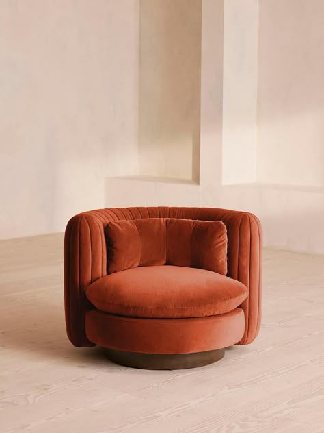 An extension of our Vivienne range, this swivel armchair takes its inspiration from the 1960s-inspired interiors of White City House. Upholstered in a cotton velvet fabric, pleated stitch detailing to the back of the chair makes it a versatile piece to sit in any area of the living room while adding a tactile point of interest. The oversized curved shape is an elevated take on the classic tub armchair, created for cozy, conversational moments in mind. Soho Home Vivienne Armchair, Velvet, Rust | Classic Luxury Living Room, Curved Sofas, Affordable Sofa, Urban Outfitters Home, Velvet Lounge Chair, Parisian Decor, Luxury Living Room Decor, Reception Sofa, Soho Home