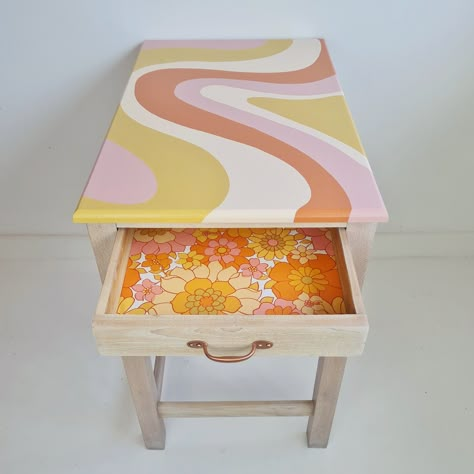 Painted desk with a flowing stripe desk design and an open drawer which has been lined with retro floral wallpaper. Cute Home Decor Paintings, Colorful Side Table Diy, Funky Painted Side Table, Fun Painted Table, Funky Desk Ideas, Painted Stools Diy, Aesthetic Table Painting, Wallpaper A Table, Diy Funky Side Table