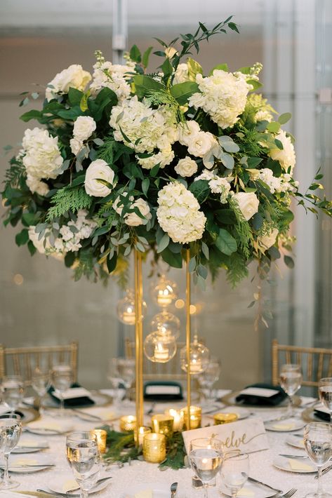 Green, Gold and White Glamorous Holiday Season wedding at Venue Six10 in Chicago, Illinois by wedding planner A Fresh Event (photo by Jenna Marie Photo) // Dramatic centerpiece with hanging candles White And Gold Wedding With Greenery, Hanging Candles Centerpiece, Emerald Green And Gold Centerpieces Wedding, Gold White Flower Arrangement, White And Green Centrepiece Wedding, White And Gold Centerpiece, White Green Gold Flower Arrangements, Hanging Tea Lights Wedding Centerpieces, Gold Vase White Flower Centerpieces