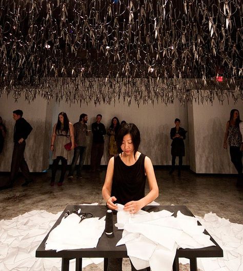 photo by Rick Kern Artist Beili Liu calmly sewed pieces of fabric together while sitting under hundreds of precariously suspended scissors in the performance piece "The Mending Project" (video). Vi... Preformance Art, Time Based Art, Ephemeral Art, Beautiful Decay, Colossal Art, Design Textile, Performance Artist, Night Art, Sculpture Installation