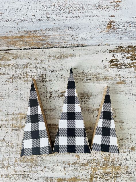 Black & White Buffalo Check Wooden Trees is a set of three freestanding wooden sitters. Trees have a distressed black and white buffalo check pattern with white distress marks on their sides and they pair well with rustic and primitive holiday displays. They look great together or scattered throughout a room and measure 8" high by 3.25" wide by 1" deep; 7" high by 3" wide by 1" deep; and 6" high by 2.5" wide by 1" deep. Wooden Trees, Wooden Tree, Decor Figurines, White Buffalo, Buffalo Check, Check Pattern, Buffalo, Seasonal Decor, Figurines