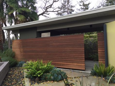 Ipe wood, a flame-resistant, durable wood from South America, is placed in a horizontal pattern for this sliding fence. The design by architect Guy Ayers provides privacy when desired but blurs the lines between interior and exterior when open. Modern Backyard Furniture, Mid Century Modern Fence, Mid Century Modern Backyard, Modern Wood Fence, Modern Backyard Design, House Contemporary, Mid Century Modern Exterior, Modern Courtyard, Mid Century Exterior