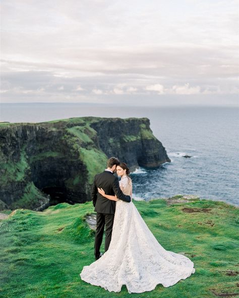 Ethereal Romance // Beneath the soft glow of the rising sun, the Cliffs of Moher serve as nature’s perfect canvas for love. The gentle morning light wraps around the couple like a tender embrace, while the breeze dances along the cliffside, whispering promises of forever. Her lace gown, intricate and timeless, mirrors the rugged beauty of the landscape, while their shared gaze speaks volumes—it’s as though the world stands still in this sacred moment. Here, on the edge of the world, love find... Cliffside Wedding, Cliffside Wedding Ceremony, Sunset Cliffs Wedding, Cliffs Of Moher Wedding, Cliff Side Elopement, Wedding Cliff Ocean, Cliff Wedding, Tender Embrace, Cliffs Of Moher