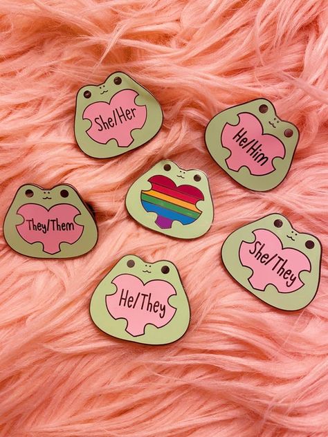 These froggos have pronoun pride! Wear your pronouns with these 1.5 inch frog enamel pins. Each pin has two clutches on the back for extra security and comes secured to a cute rainbow backing card. Pronoun Pins, Transgender Flag, Pride Wear, Frog Pins, Lgbt Art, Frog Art, Cool Pins, Cute Frogs, Cute Pins