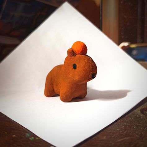 Capybara with orange on its head Cute Clay Capybara, Gort Capybara, Cute Mini Sculptures, Capybara Clay Sculpture, Air Dry Clay Capybara, Easy Sculpey Clay Ideas, Capybara Clay Art, Simple Sculpture Ideas, Clay Mini Figures