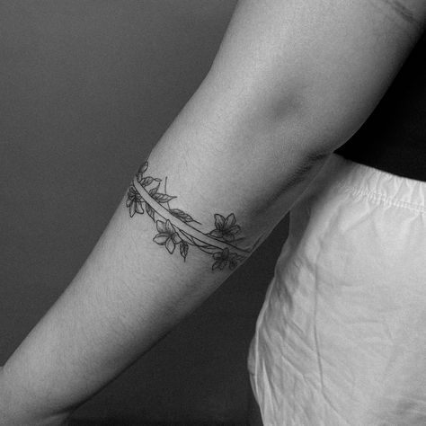 An armband tattoo featuring sampaguita flowers often carries cultural and personal significance. The sampaguita, also known as the Philippine jasmine, is the national flower of the Philippines. It symbolizes purity, simplicity, humility, and strength. In the context of an armband tattoo, it may represent pride in Filipino heritage, a connection to one’s roots, or the embodiment of the qualities that the flower symbolizes. Additionally, armband tattoos can signify continuity, protection, and l... Filipino Sampaguita Tattoo, Sampaguita Flower Tattoo Philippines, Filipino Tribe Tattoo, Filipina Tattoo, Sampaguita Tattoo, Filipino Tattoo Ideas, Sampaguita Flower Tattoo, Traditional Filipino Tattoo, Philippines Tattoo